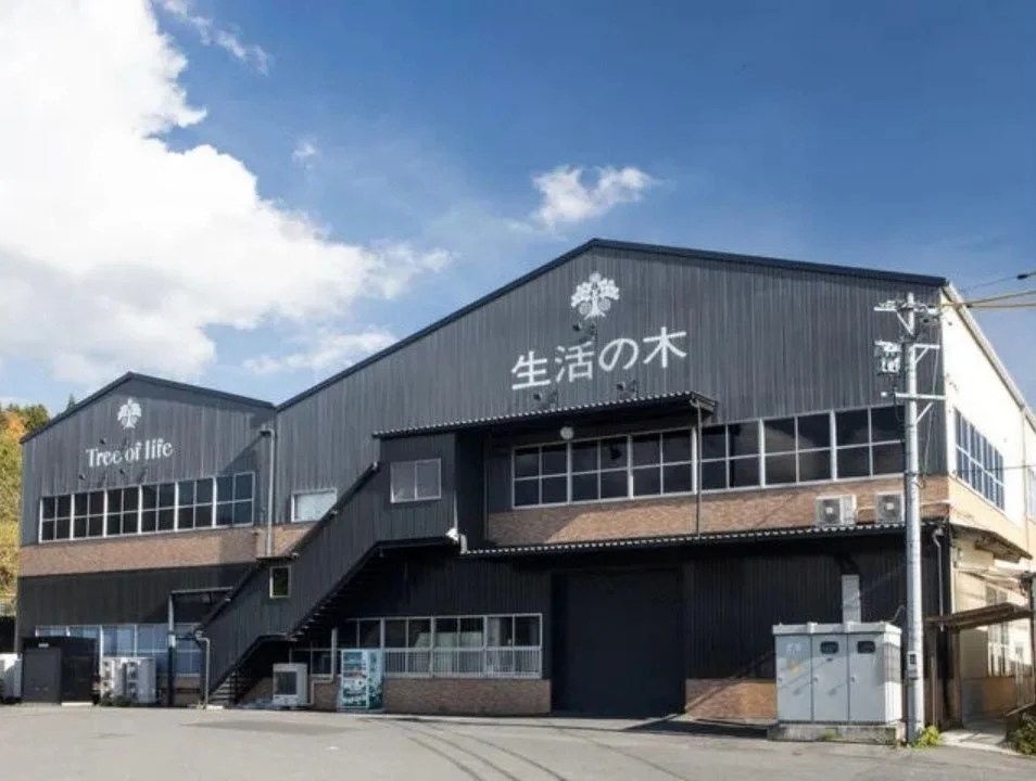 Tree of lifeと生活の木の看板がある濃い灰色の2階建ての建物