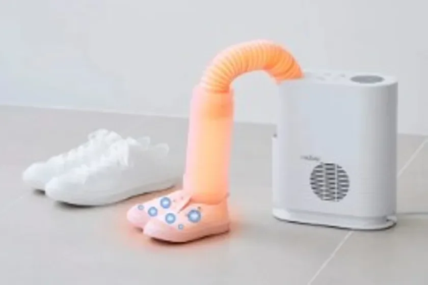 靴乾燥機がピンクの靴を乾燥させている様子です。隣には白いスニーカーも置かれ、日常の靴のお手入れに便利な家電製品が紹介されています。