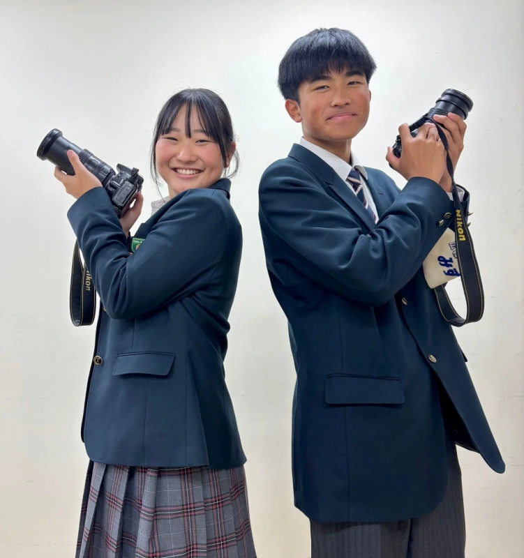 制服を着た男女の学生がカメラを構えているポートレート